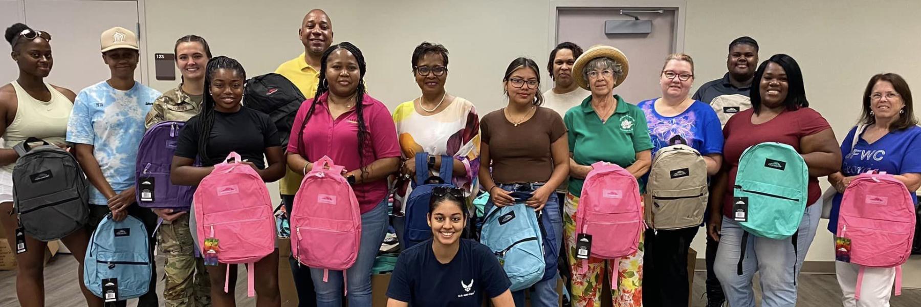 volunteers filling backpacks with school supplies